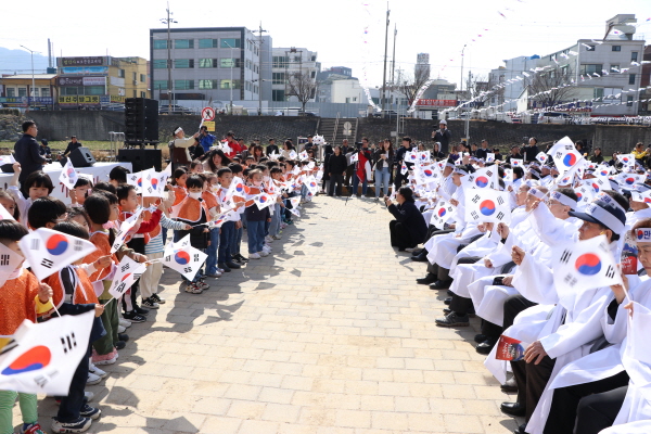 행사에 참석한 참석자들과 어린이들이 함께 태극기를 흔들며 광복군가를 부르고 있다.
