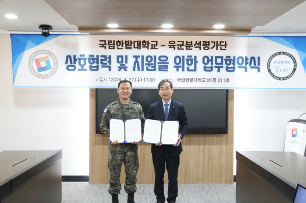 지난 27일 열린 국립한밭대학교와 육군분석평가단 간 업무협약식에서 국립한밭대 오용준 총장(오른쪽)과 육군분석평가단 전남주 단장이 협약서에 서명 후 기념촬영을 하고 있다.