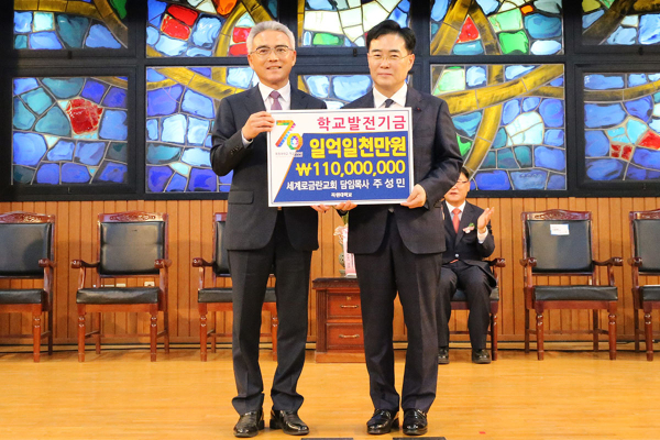 주성민 세계로금란교회 담임목사(오른쪽)가 이희학 총장에게 대학발전기금 1억1000만원을 전달하며 기념촬영을 하고 있다