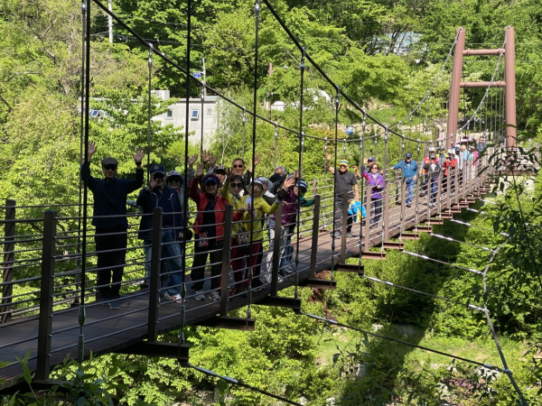 지난달 파독 근로자들이 경북 김천시 증산면 국립김천치유의숲에서 산림치유 캠프를 진행한 뒤 인근 용추폭포에서 기념촬영을 하고 있다.