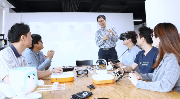 최용근 교수(가운데)가 학생들과 함께 AI·로봇·IoT 기술을 활용해 사회적 약자를 위한 연구를 수행하고 있다.