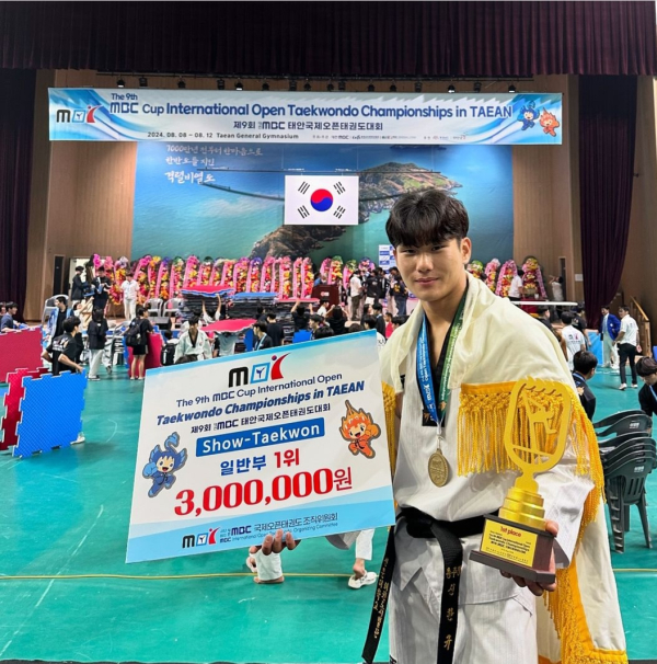 신한규 학생이 자유품새 개인전 18세 이상부에서 1위 수상 후 포즈를 취하고 있다.