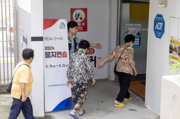 주민들이 안내요원의 지시에 따라 지하대피소로 이동하고 있다.