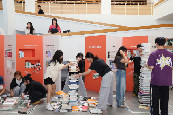 ‘SCH 도서전 – 힙한 책힐링’에서 재학생들이 ‘책-탑 쌓기’ 프로그램에 즐겁게 참가하고 있다.