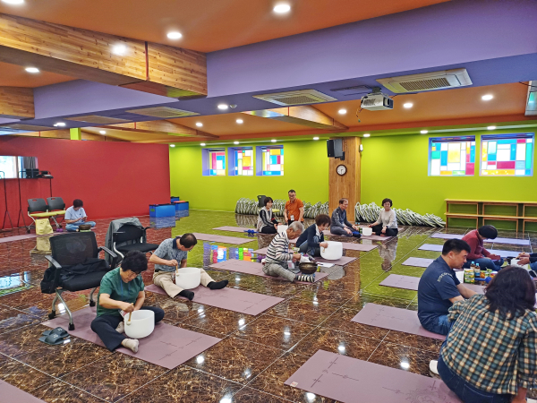 산재근로자 및 가족들이 싱잉볼 명상 프로그램에 참여하며 직접 싱잉볼을 연주해보는 모습.