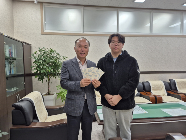 김현 학생이 장학금을 교환해 관내 교육청에 기부하고 있다.