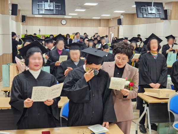 졸업의 감격에 눈물 흘리는 만학도를 위로하는 최선희 대전평생교육진흥원장.