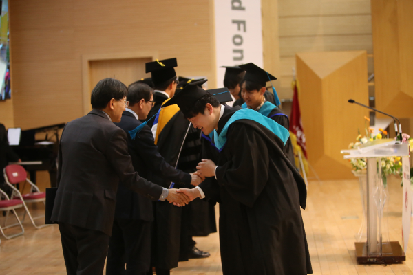 학위수여식에서 졸업생들이 교수님들과 인사를 나누고 있다.