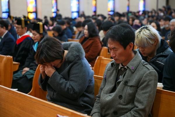 20일 오전 목원대 채플에서 열린 ‘2024학년도 전기 학위수여식’에서 고 박가영씨의 어머니와 아버지가 박가영씨의 명예졸업증서를 받은 뒤 자리에 앉아 있다.