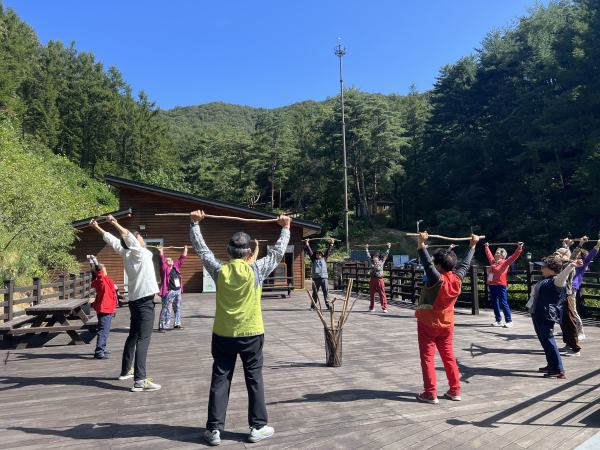 지난해 가을 국립양평치유의숲에서 진행한 ‘나눔의숲 캠프’ 참가자들이 ‘으쌰으쌰 숲속운동(편백봉체조)’를 하고 있다