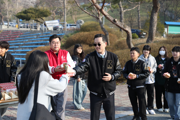 유주현 총장과 학생회 임원들이 등교케어 행사에서 학생들에게 아침 간식을 건네주고 있다