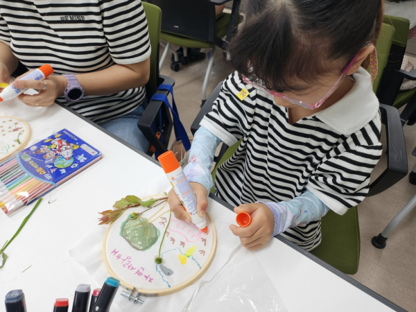 수틀 액자 위에 숲에서 느꼈던 내 마음을 표현해 보고 있다.