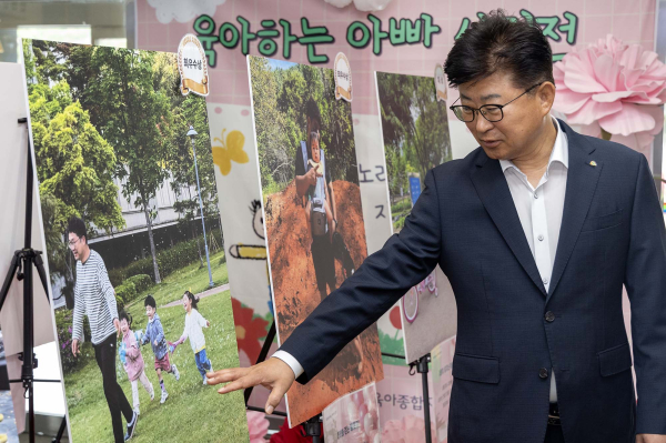 최충규 대덕구청장이 육아하는 아빠 사진 공모전 수상 작품을 감상하고 있다.