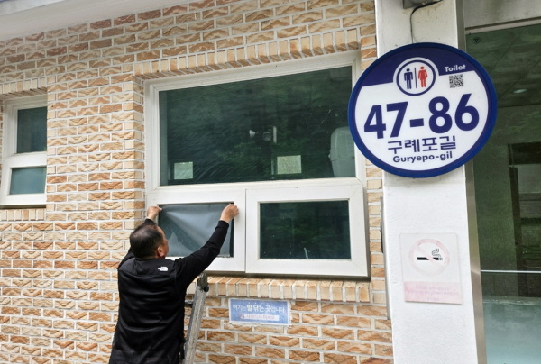이달 초 공중화장실 유리창에 불투명 시트지를 부착하는 모습