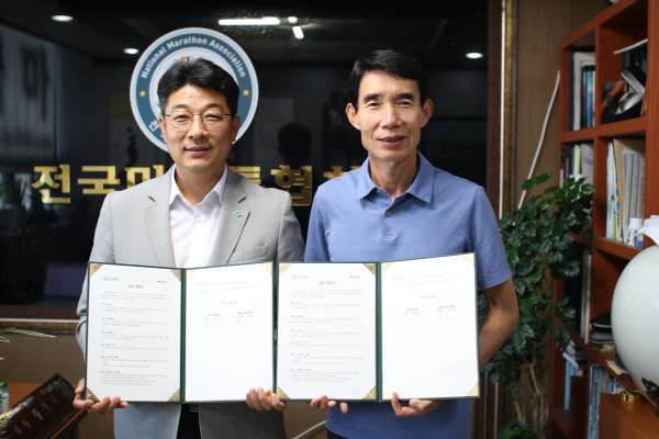 초록우산 최승인 충청권역본부장과 전국마라톤협회 장영기 회장이 업무협약서를 들고 기념촬영을 하고 있다.