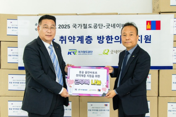 권병희 글로벌본부 몽골지사장(왼쪽)이 전홍수 굿네이버스 몽골사업장 대표(오른쪽)에게 근무복을 전달 후 함께 기념촬영을 하고 있다.