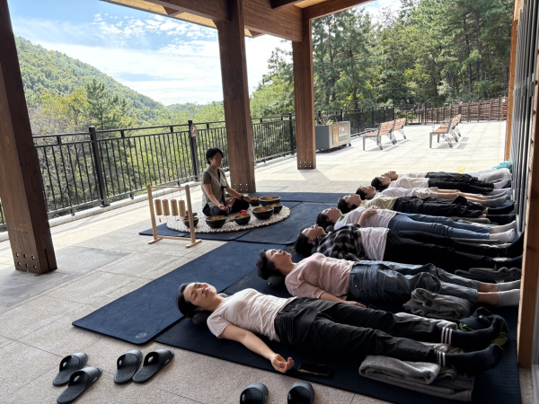 26일 국립부산승학산치유의숲에서 내맘돌봄 캠프 참가자가 싱잉볼 명상 산림치유프로그램에 참여하고 있다.