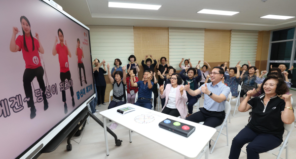 박희조 동구청장과 어르신들이 스마트경로당 3호점 자양동 백룡경로당에서 스마트 뮤직헬스시스템을 이용해 율동을 하고 있다.