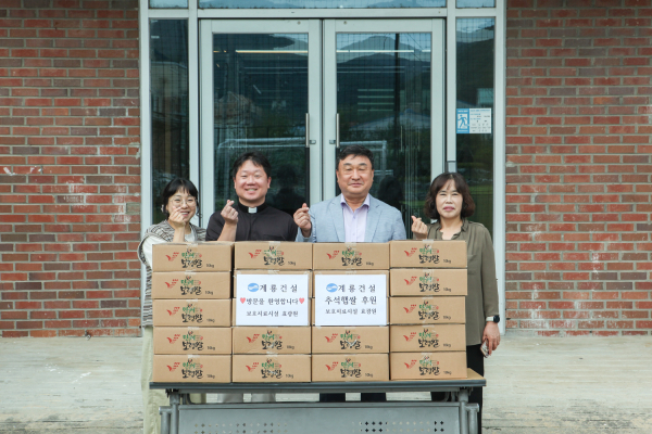 계룡건설 진중길 상무(오른쪽에서 두번째)가 청소년사회복지시설 효광원 김현 원장(왼쪽에서 두번째)에게 위문품을 전달하고 관계자들과 기념 촬영