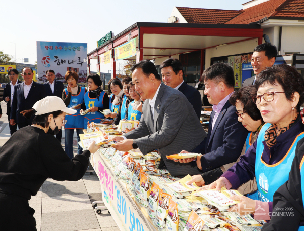 어기구위원장(가운데)과 농주모 임원들이 방문객에게 쌀을 나눠주고 있다.