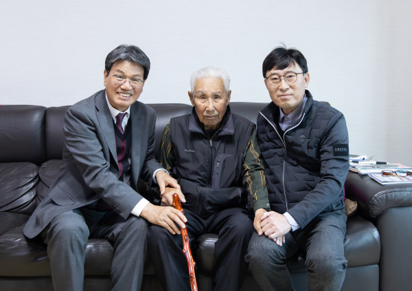 100세를 맞은 화성면 농암리 어르신께 장수지팡이(청려장)를 전달하며 축하 인사를 나누고 있는 김돈곤 군수(왼쪽)와 조형섭 화성면장(오른쪽).