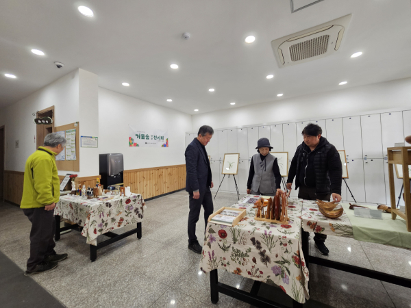 국립양평치유의숲 로비에 전시된 다양한 세밀화와 목공예품을 고객들이 관람하고 있다.