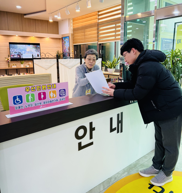 군 행복민원과를 방문한 민원인에게 어르신 민원안내 도우미가 안내를 하고 있다.