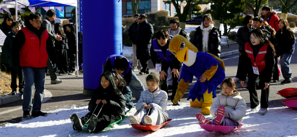 아이들과 쿰장들이 눈썰매를 타고 있다