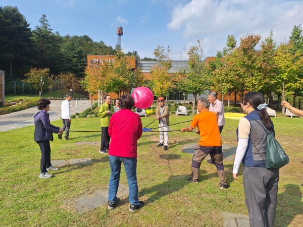 춘천시 지역 어르신들이 국립춘천숲체원 아침못마당에서 숲밧줄 운동 프로그램에 참여해 즐기고 있다.