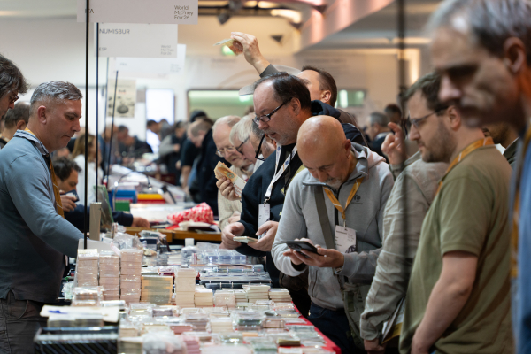 박람회 내 판매부스에서 관람객들이 다양한 화폐를 구경하고 있다