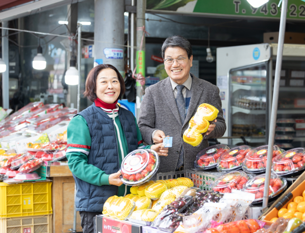 지난달 27일 김돈곤 청양군수가 농어촌 기본소득 지급 첫날 청양 전통시장을 방문해 물품을 구매하며 상인들의 애로사항을 청취하고 있다.
