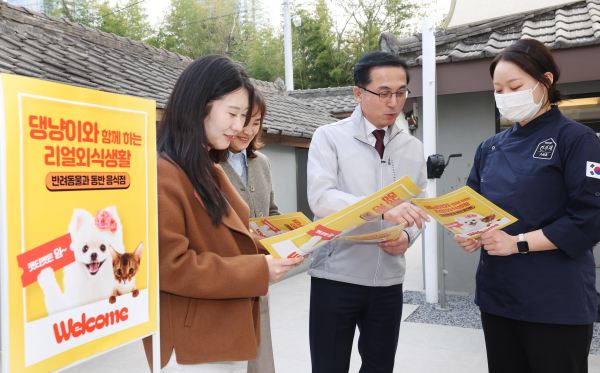 박희조 동구청장과 직원들이 반려견 동반음식점에서 설명을 듣고 있다.