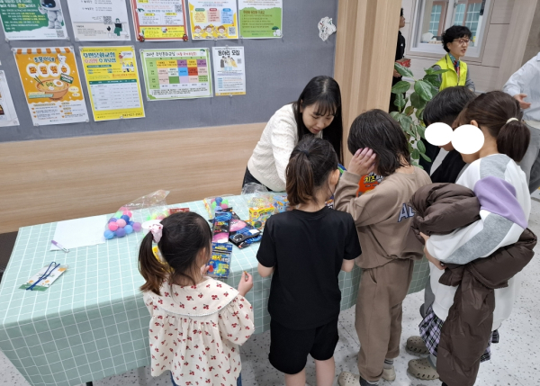 어린이식당 이용 아동이 추억의 선물뽑기 이벤트에 참여하며 즐거워 하고 있다.