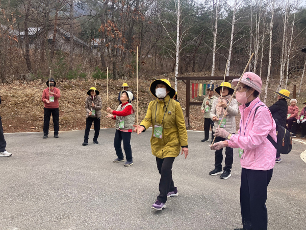 8일 춘천숲체원 놀이숲에서 소양강댐노인복지관 어르신들이 나무 스틱을 활용한 균형         감각 키우기 치유 프로그램에 참여하고 있다.