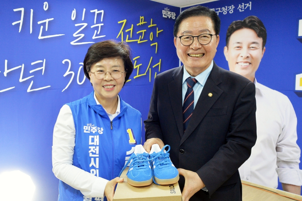 장종태 의원이 손도선 대전시의원 후보에게 파란 운동화를 전달하고 있다.