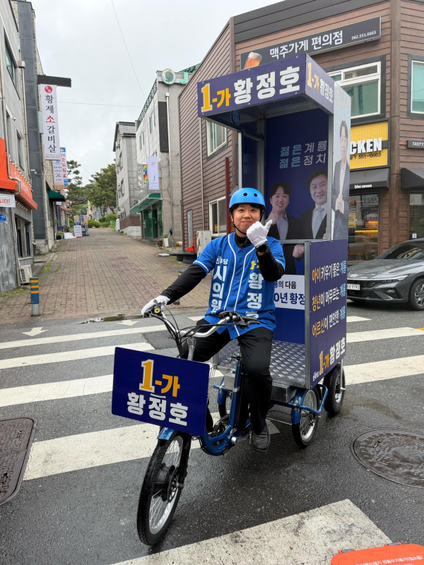 황정호 후보가 전기자전거를 타고 거리유세를 펼치고 있다
