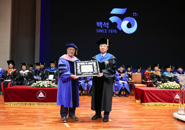 백석대학교 설립자 장종현 박사(오른쪽)가 명예예술학박사 학위를 받은 박경진 회장에게 축하패를 전달한 뒤 기념촬영을 하고 있다.