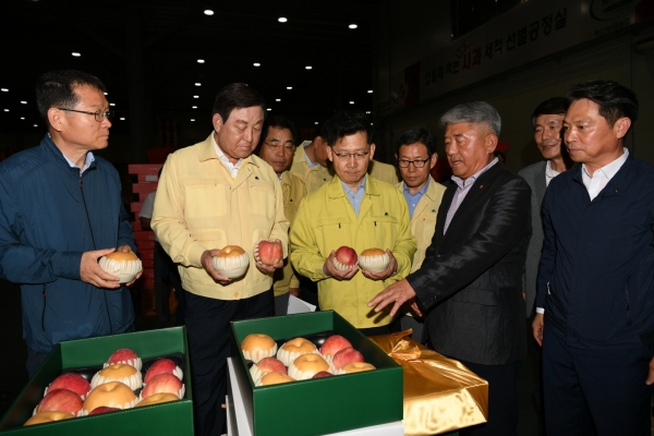 황선봉 군수와 김현수 장관이 능금농협 관계자로부터 설명을 듣고 있다