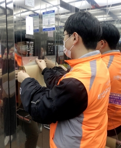 아파트 엘리베이터에 항균필름을 붙이는 모습.