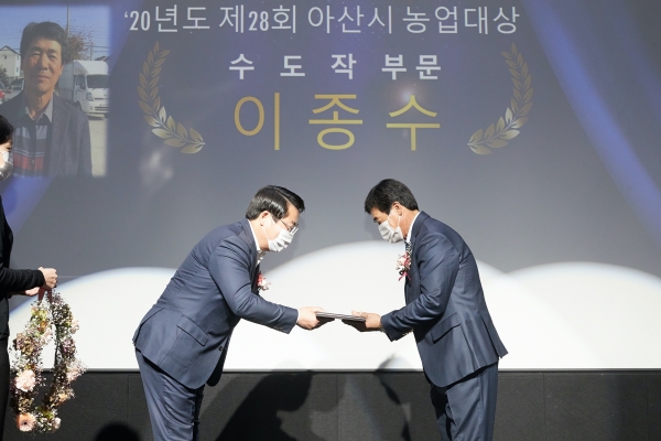 오세현 시장이 농업대상 수도작부문 수상자 이종수에게 상패를 건내고 있다