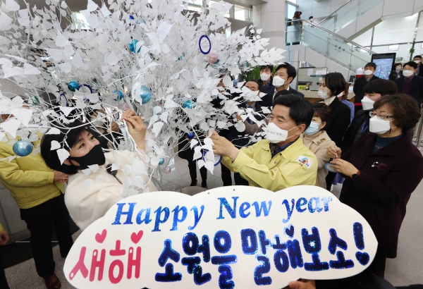 소원나무에 소원을 적어 달고 있는 모습