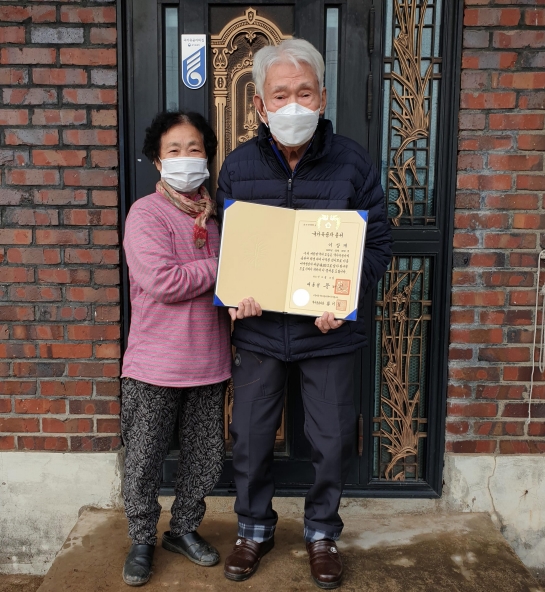 참전유공자 이상재씨의 자택 현관에 ‘국가유공자의 집’ 문패를 부착하고 이상재씨 부부가 기념촬영을 하고 있다.