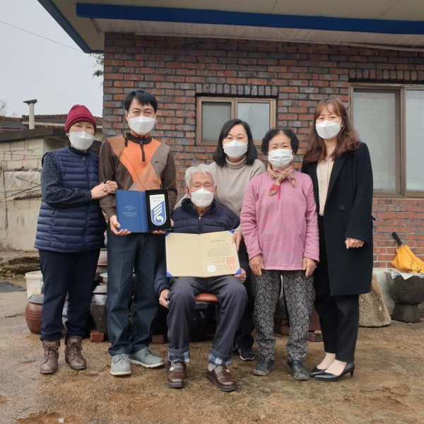참전유공자 이상재씨의 자택에서 국가유공자 증서 전수식을 갖은 후 자녀들과 함께 기념촬영을 하고 있다.               ( 앞줄 가운데 이상재씨, 오른쪽 첫 번 째 보상과장 김지숙)