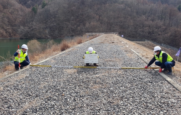 공사 직원들이 저수지 정밀안전점검을 위해 저수지 댐마루 상태 조사를 실시하고 있다