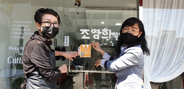 어르신 목욕 및 이·미용권 가맹업소 스티커를 부착하고 있다