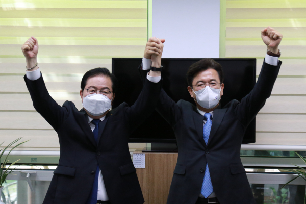 허태정 대전시장과 장종태 전 서구청장이 민주당 대전시장 경선 발표 다음날인 26일 두손을 마주 잡고 있다.