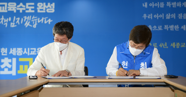 협약서에 서명하는 최교진 후보와 유근준 회장
