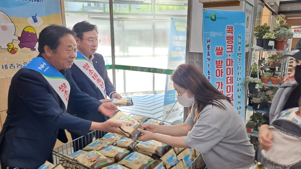 임유수 세종중앙농협조합장(왼쪽)과 이종욱 충남세종농협본부장(가운데)이 농협상호금융 디지털금융과 연계한 쌀소비 촉진 캠페인에서 농협을 찾은 고객에게 쌀을 선물하고 있다.