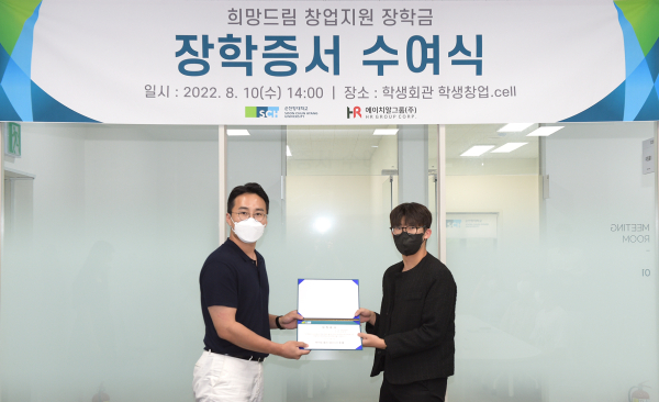 에이치알그룹㈜ 신호룡 대표이사가 유니브팅 성준혁 대표(정보보호학과 4)에게 희망드림 창업지원 장학증서를 전달하고 있다.