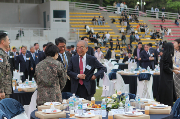 한국영상대학교 유재원 총장이 행사에 참석한 내빈에게 인사를 건네며 환하게 웃고 있다.